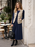 Model wearing a navy blue wool pleated midi dress with a check linen vest